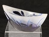 a glass bowl sitting on a clear stand on a black background
