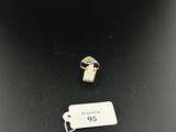 a gold ring with a diamond on top of it next to a tag