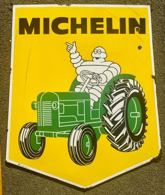 panneau jaune et vert représentant un homme au volant d'un tracteur
