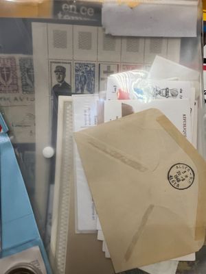 a pile of mail sitting on top of a desk next to a computer
