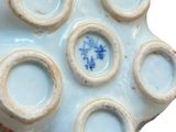 someone is holding a vase in their hand and it is decorated with blue and white designs