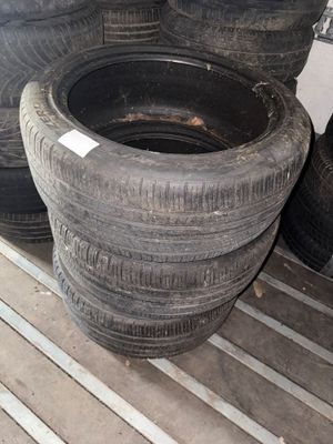 Plusieurs vieux pneus sont empilés sur une étagère dans un garage.