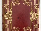 an old red book with gold trimmings and a decorative design