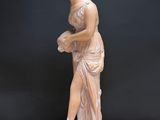 an image of a statue of a woman holding a flower