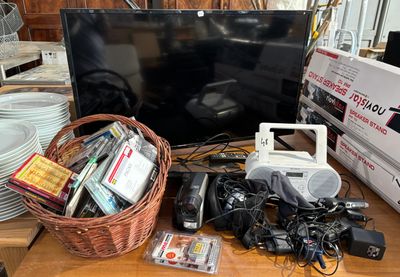 a basket full of electronics on a table next to a television