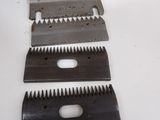 three blades of a metal cutting board on a white surface