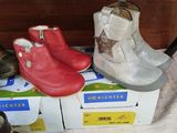 several pairs of children ' s shoes sitting on top of a box