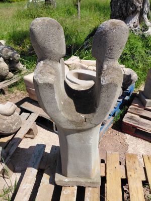 une statue représentant un homme et une femme, réalisée en ciment