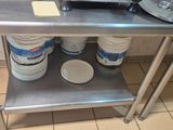 a metal table with two buckets of milk on it