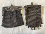 paire de petits sacs à main anciens en maille métallique argentée, posés sur un tissu blanc
