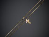 un collier avec une croix en or et une chaîne en or sur fond noir
