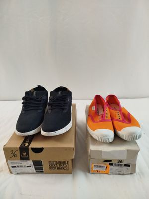 deux paires de chaussures de tennis noires et orange posées sur une boîte