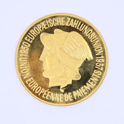La pièce est en or et représente le visage d'une femme.