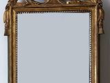 a mirror hanging on the wall with a bird on it