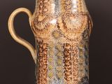 a brown and blue vase sitting on a wooden table