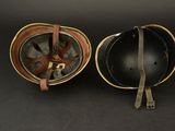 two helmets are sitting side by side on a black surface