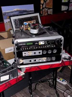 un ordinateur portable posé sur une table, à côté d'une table de mixage