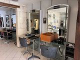 a room with a mirror and chairs and a mirror on the wall