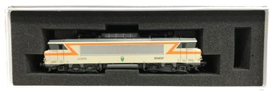 un petit train dans une boîte posée sur une surface blanche