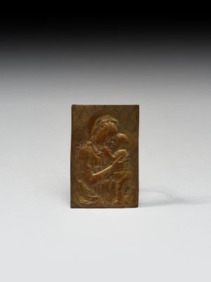 une plaque en bronze représentant une femme tenant un enfant dans ses bras