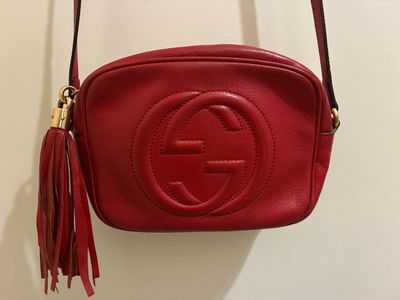 un sac Gucci rouge accroché au mur