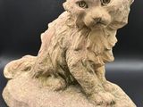 un gros plan sur la statue d'un chat assis sur un rocher
