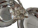 a silver plate with a flower on top of it