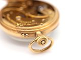 a close up of a pocket watch on a white surface