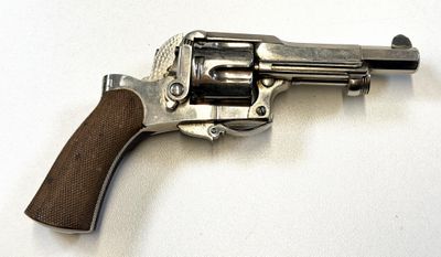 pistolet posé sur une surface blanche, muni d'une crosse en bois