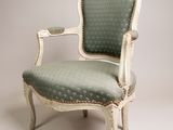 an old chair with a green upholstered seat on a white background