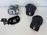 trois casquettes des Yankees de New York et une casquette de baseball posées sur une table