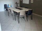 une pièce équipée d'une table, de chaises et d'un réfrigérateur