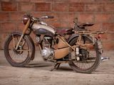 a old motorcycle that is parked in front of a brick wall