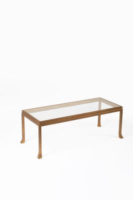 une image représentant une table basse avec un plateau en verre sur fond blanc