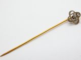 un gros plan d'un bâton doré orné d'une fleur