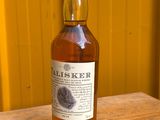 une photo d'une bouteille de whisky posée sur une table en bois