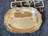 a silver tray on the floor next to a blue rug