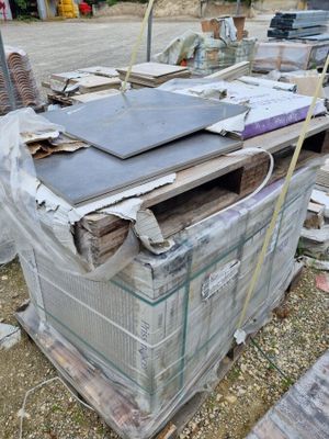 un tas de vieilleries par terre, à côté d'un immeuble