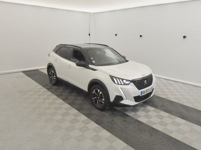 Le SUV blanc est garé dans une pièce blanche au sol à carreaux.