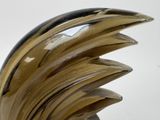 a glass sculpture of a wave on a white surface
