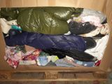 a cardboard box filled with clothes and a sleeping bag