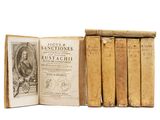 several old books are stacked on top of each other on a white surface