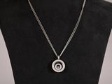 un collier noir et blanc orné d'un motif en spirale, présenté sur un mannequin