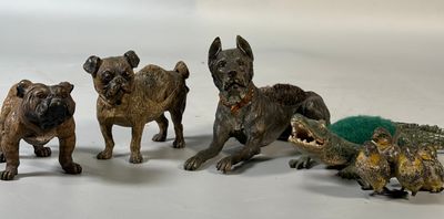 cinq figurines représentant des chiens et un crocodile sur un fond blanc