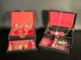 two boxes that have jewelry inside of them on a table