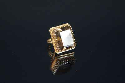 un gros plan d'une bague en or sertie d'une pierre blanche