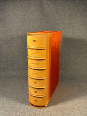 an orange book sitting on top of a table next to a gray wall