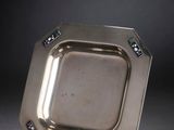 silver plate with blue and white stones on it on a black surface