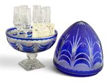 a blue glass bowl with wine glasses and a tray with wine glasses on it