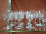 many wine glasses on a glass shelf in a store